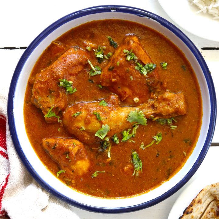 aerial shot of chicken curry in a white serving bowl