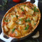 side shot of cheesy potato bake in a white ceramic baking dish