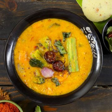 aerial shot of vegetable sambar in a black ceramic bowl