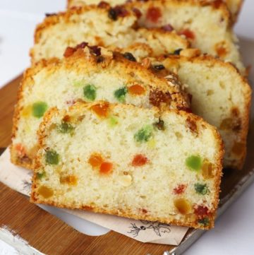 side shot of eggless tutti frutti cake stacked on a platter