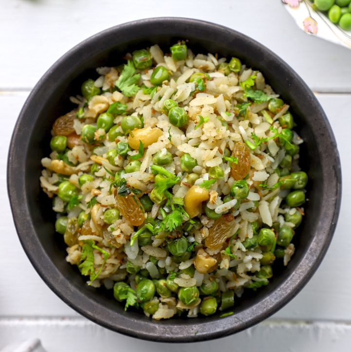 aerial shot of matar poha served in a black ceramic bowl