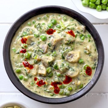 aerial shot of methi matar malai in a black ceramic bowl