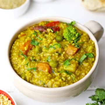 side shot of vegetable millet khichdi in a glass mug