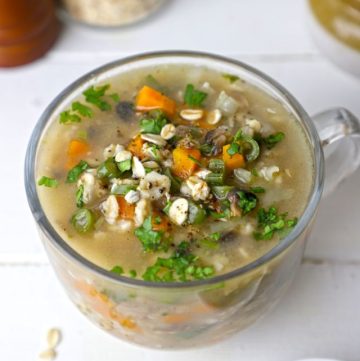 side shot of vegetable oats soup in a glass mug