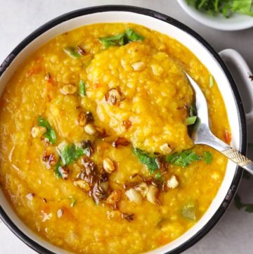 aerial shot of masoor dal in a white ceramic bowl with spoon