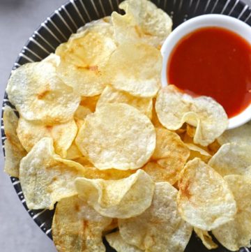 aerial shot of potato chips with ketchup in a bowl