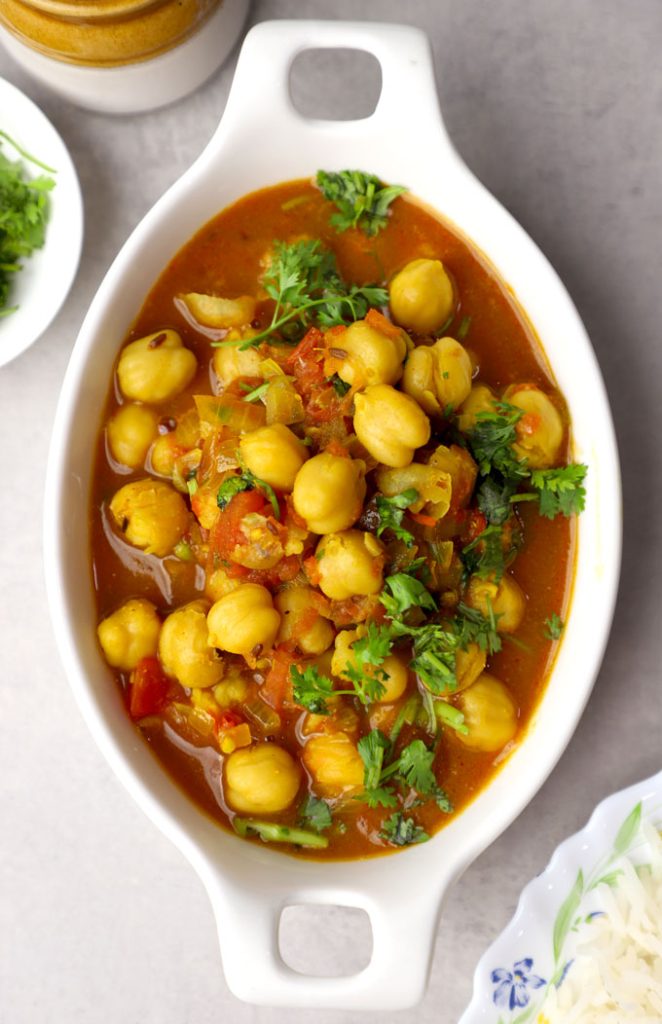 aerial shot of chana masala curry served on a white ceramic platter