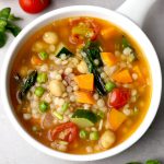 aerial shot of tomato couscous soup in a white ceramic bowl