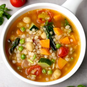 aerial shot of tomato couscous soup in a white ceramic bowl