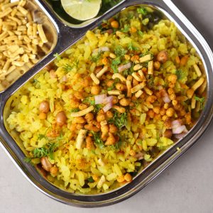 aerial shot of Indori poha served on a stainless steel plate