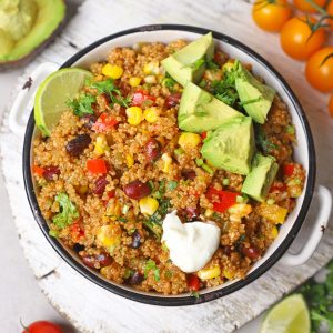 aerial shot of mexican quinoa with avocado and sour cream in a white bowl