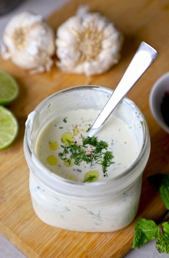 aerial close up shot of garlic yogurt sauce in a bottle