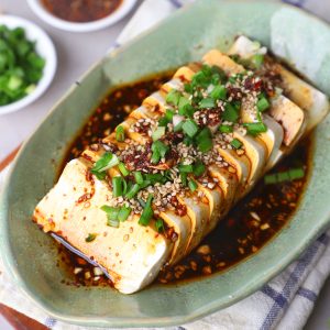 aerial shot of Chinese silken tofu served in a ceramic green platter